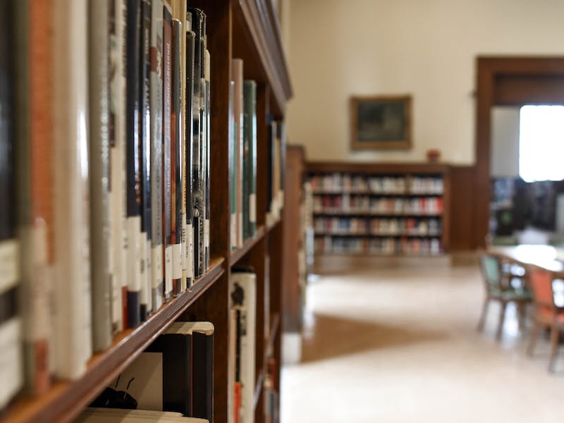 Libros en estantes y al fondo mesas para estudio